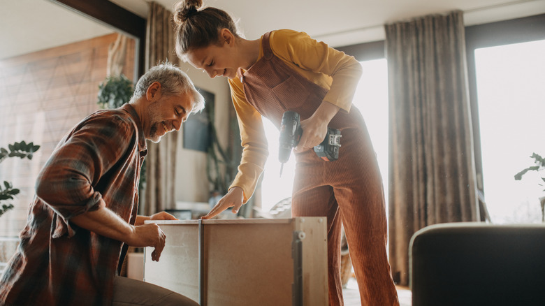 Two people putting IKEA furniture together