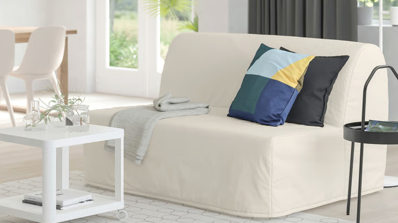 A sleeper sofa with a light beige cover