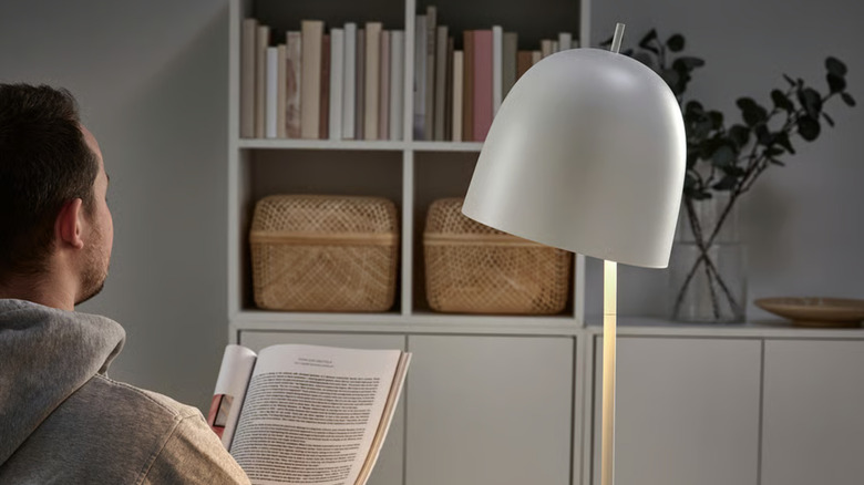 Man reading magazine by the IKEA TRINDSNÖ Lamp