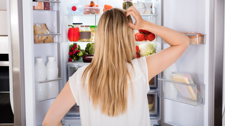 Person searching through fridge