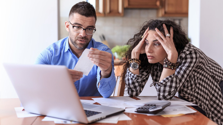 Frustrated couple looking at bills