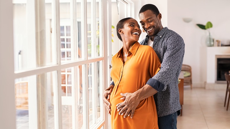 husband embracing pregnant wife