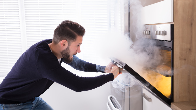 man opening oven with fire