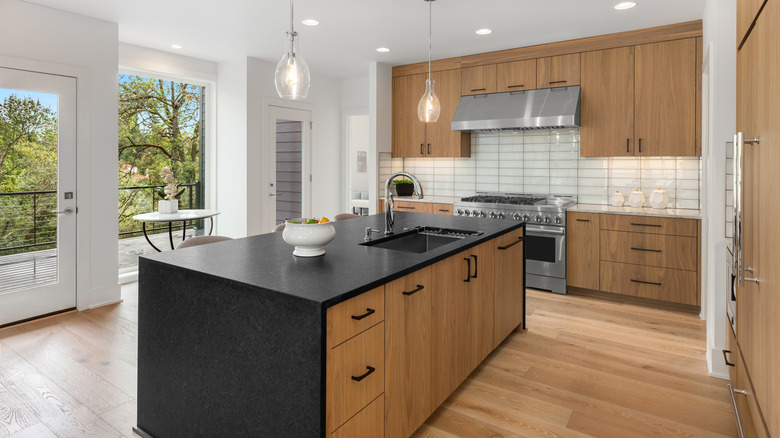 A black kitchen island in an open-concept kitchen