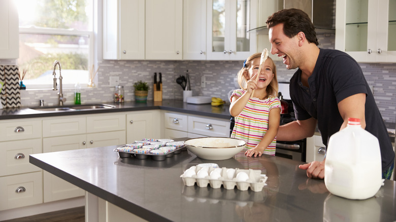 Father and daughter mixing batter for a cake at the kitchen island