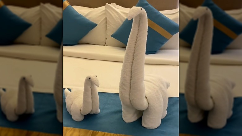 dinosaur shaped folded towels on bed