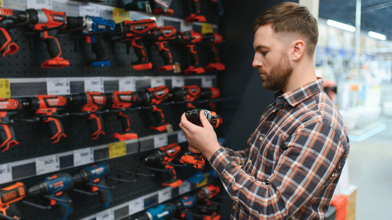 Man picking up a drill at a hardware store