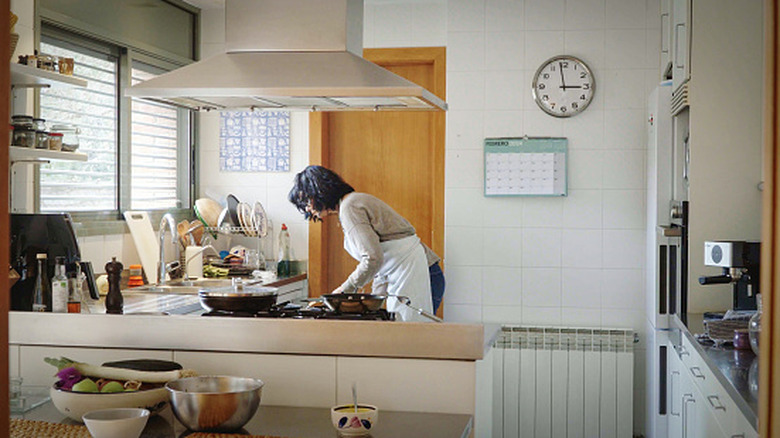 Woman cooking in 1990s kitchen