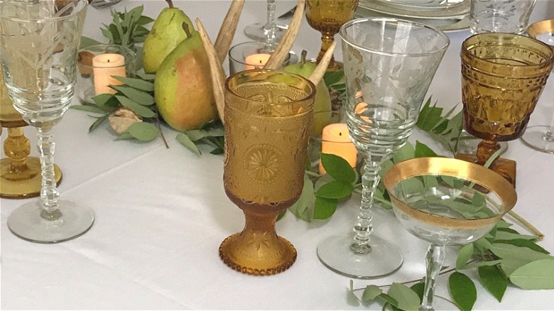 Yellow and clear wine goblets of various shapes on table