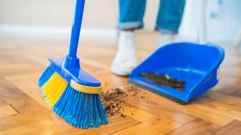 person sweeping with dustpan