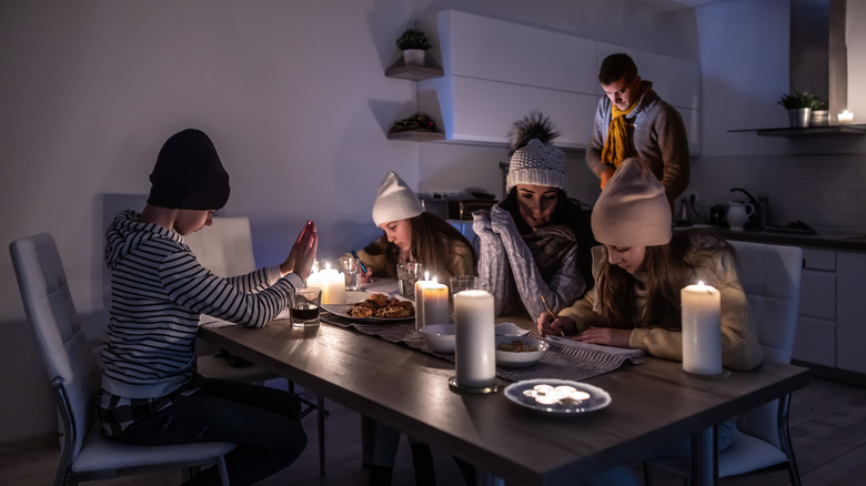 family using candles for light in power outage