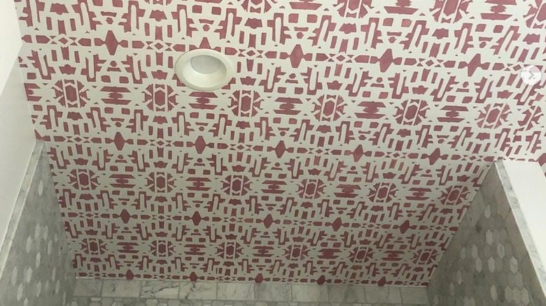 A bathroom ceiling with pink stenciled design.