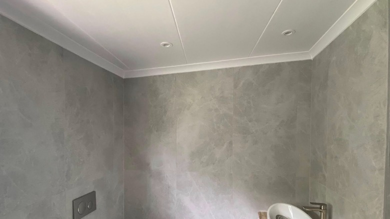 A bathroom ceiling with large white panels.