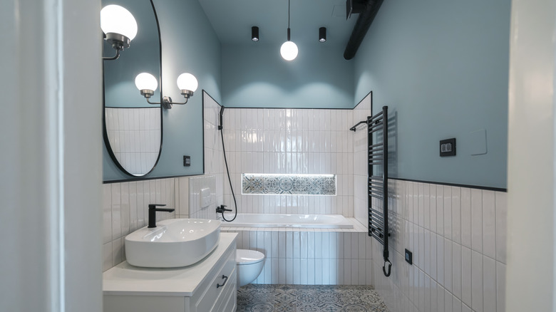 A white bathroom with blue walls and ceiling.