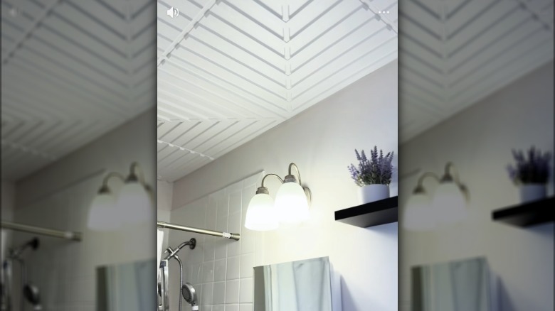 A bathroom with white textured ceiling.