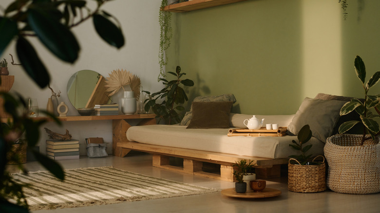 A shady living space with a low futon and lots of houseplants
