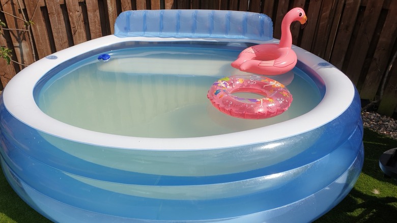An inflatable pool without a pump and with murky water inside