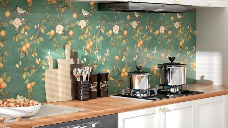 A modern kitchen with a floral wallpaper backsplash