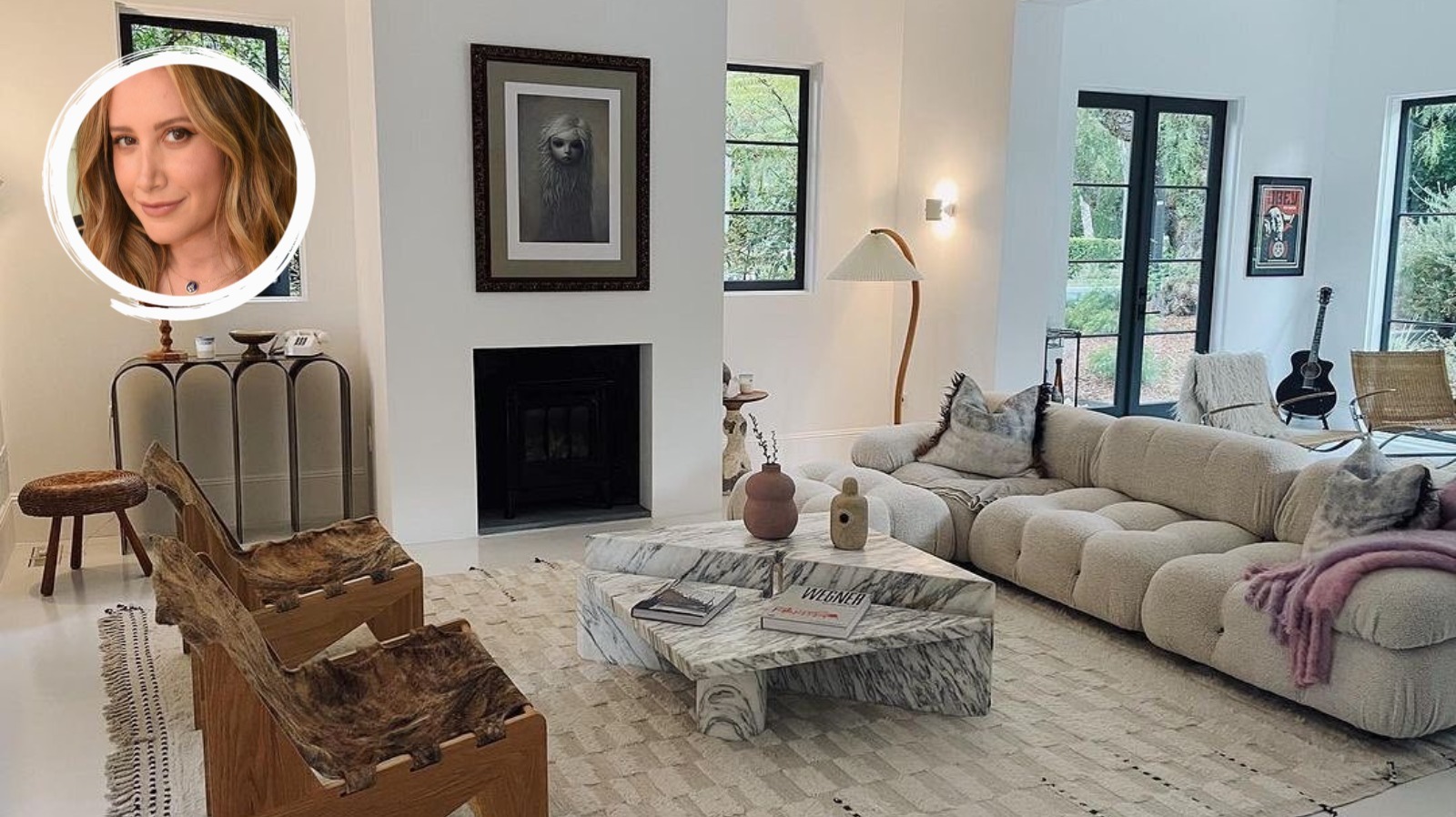 Sitting room with marble fireplace, pair of black leather button-backed  chairs and a vintage Louis Vuitton trunk coffee table