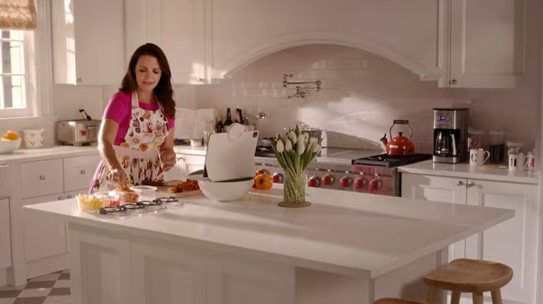 Charlotte York working in her luxurious white kitchen.