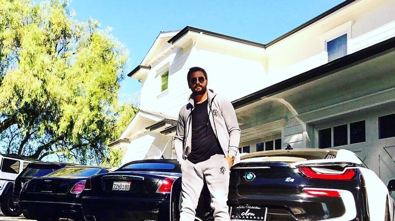 Scott Disick leaning on car