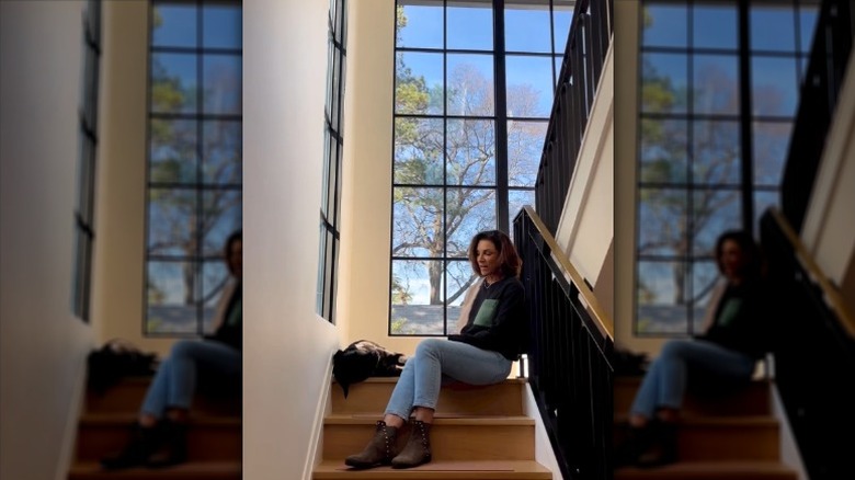 Hilary Farr sitting on her staircase and talking.