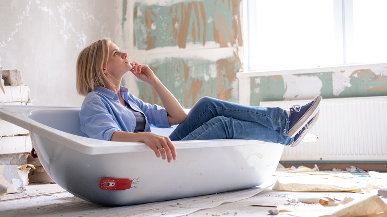 Woman thinking sitting in bathtub