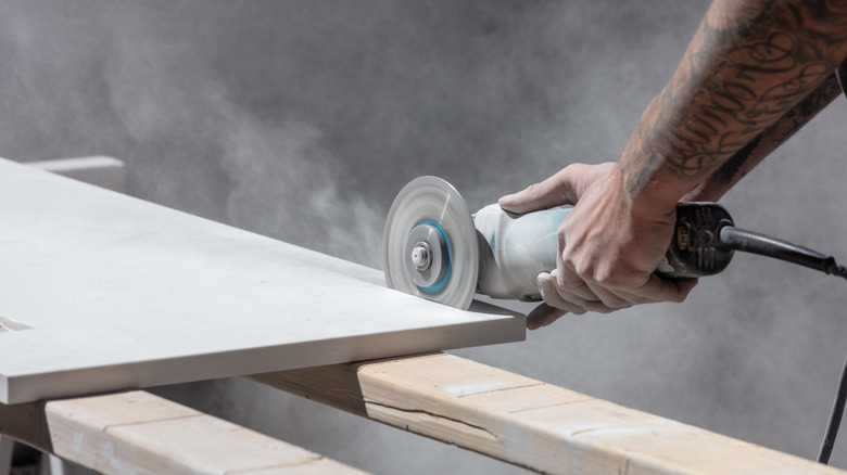 A person cutting a countertop