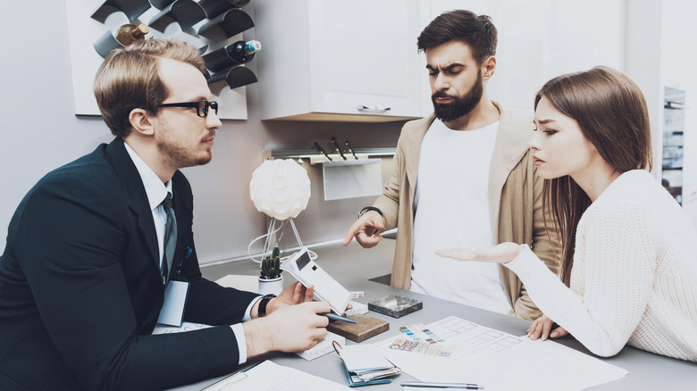 A couple negotiating with a salesperson