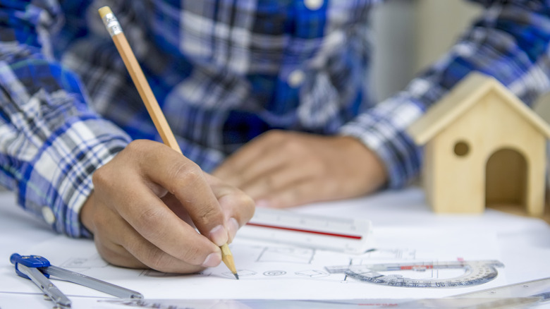 A person working out measurements for a home improvement project