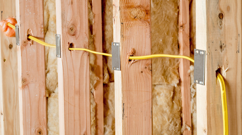 NM cable running through wall studs and protected by steel plates