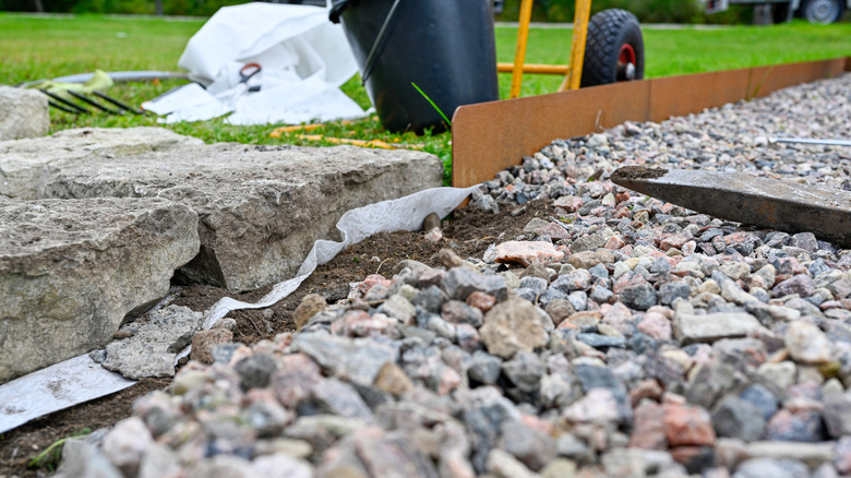 Gravel, stone, and rusty metal landscape edging in progress