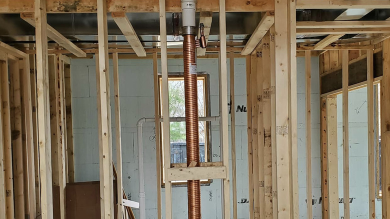 A copper gravity-film heat exchanger installed in a house that is still being built