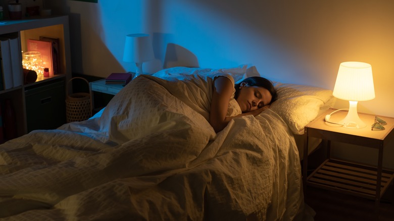 Person sleeping with lamp on