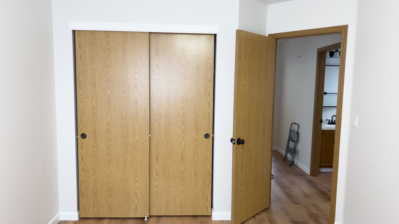 A bedroom with wooden sliding closet doors