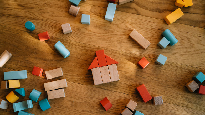 Collection of cluttered building blocks on a wooden floor