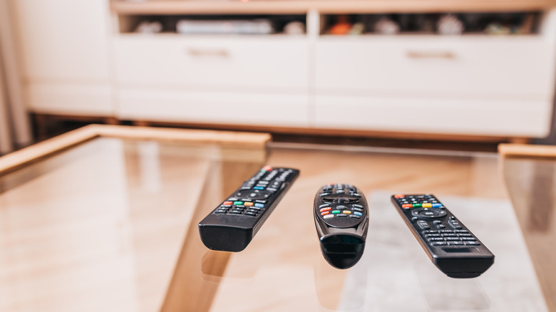 three tv remotes on coffee table