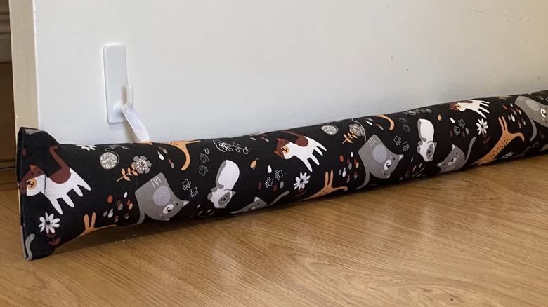 use hooks and an old pillowcase to sew a hanging draft stopper for your door