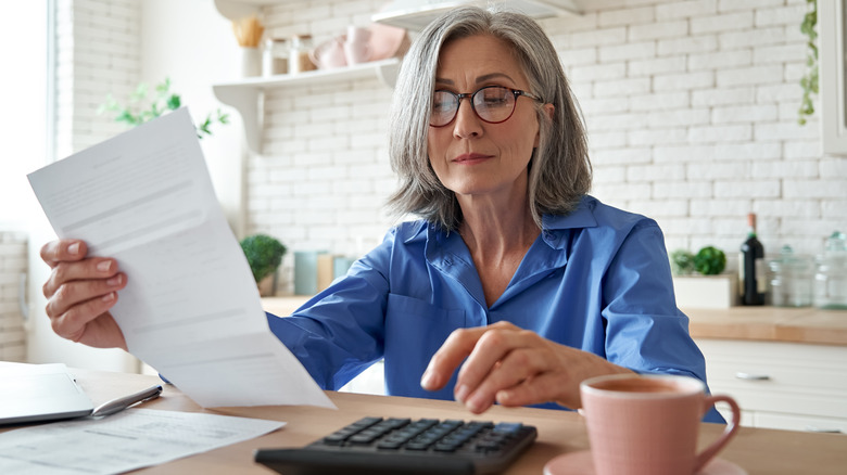 Person holding bill and calculator
