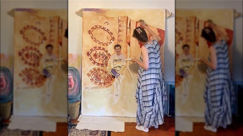 Woman painting large canvas made from a box spring