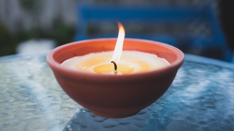 A yellow candle sitting on a blue table
