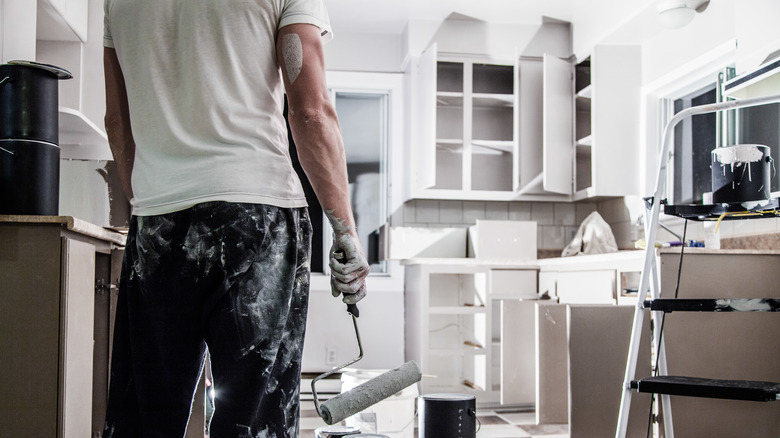 man painting kitchen cabinets