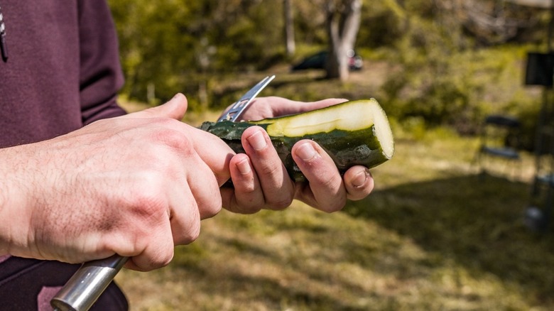 guy peeling a cucumber