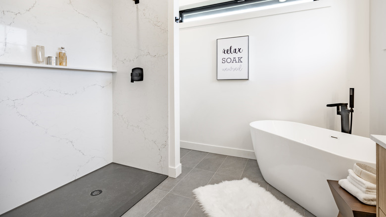 A small bathroom includes both a freestanding bathtub and a curbless, walk-in shower.
