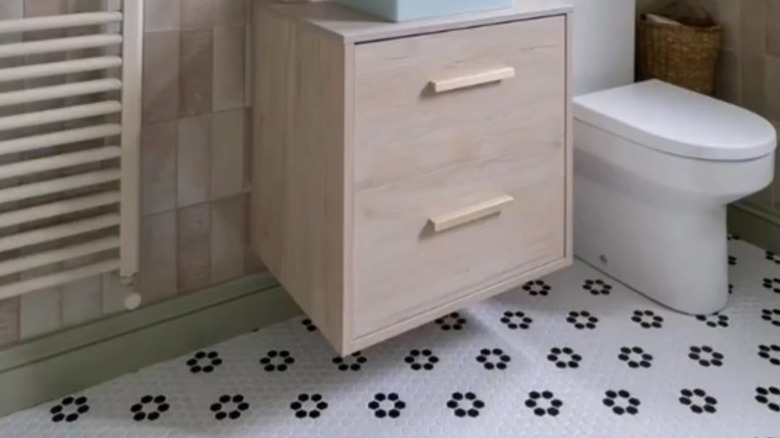 black and white mosaic hex tile in modern bathroom with toilet and modern vanity