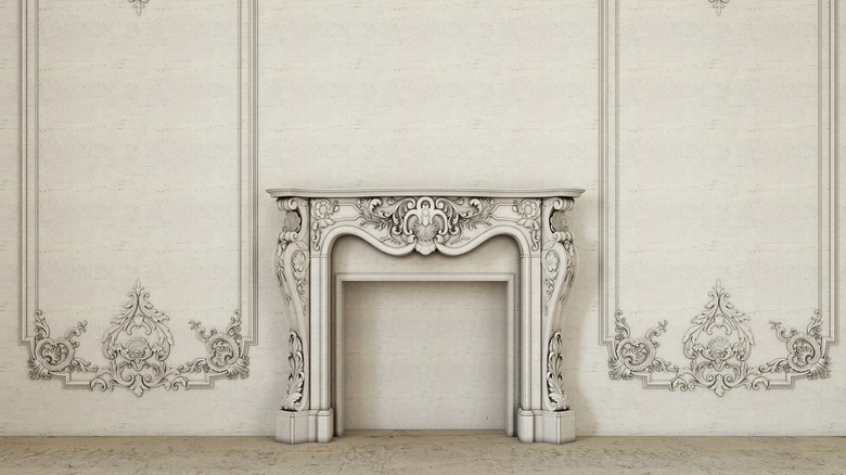 An ornate surround and mantle remain around a closed fireplace.