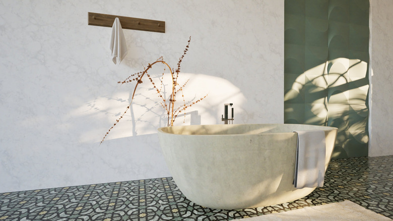 a bathroom with a freestanding stone tub, towel hanging off it