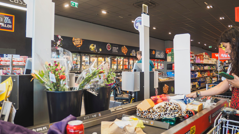 Aldi goods roll down a conveyor belt for checkout.