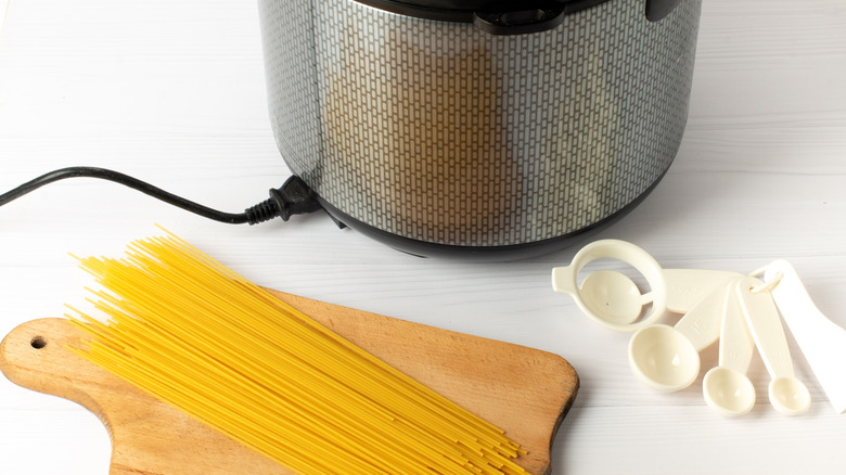 Slow cooker with pasta and measuring spoons