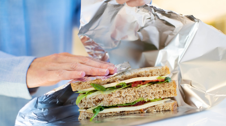 Person wrapping sandwich in foil